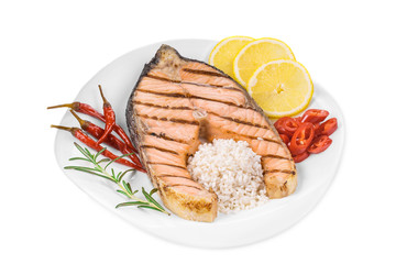 Grilled salmon steak with vegetables on plate.
