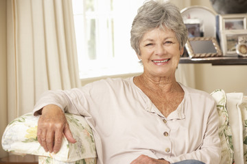Retired Senior Woman Sitting On Sofa At Home