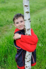 A Boy Hugging a Birch Tree