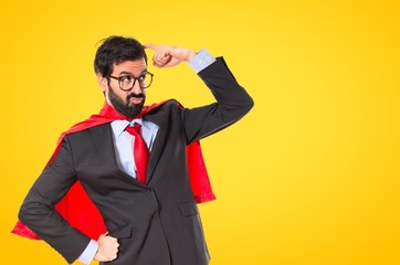 Businessman dressed like superhero thinking over white © luismolinero