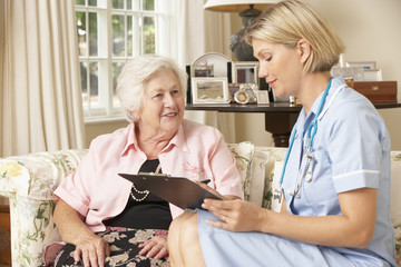 Fototapeta premium Retired Senior Woman Having Health Check With Nurse At Home