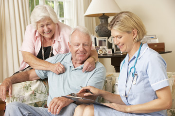 Retired Senior Man Having Health Check With Nurse At Home