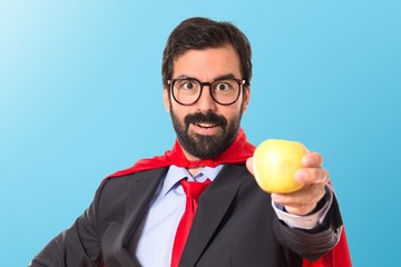 Hipster businessman dressed like superhero holding an apple