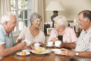 Fototapeta na wymiar Group Of Senior Couples Enjoying Afternoon Tea Together At Home