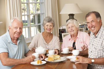 Group Of Senior Couples Enjoying Afternoon Tea Together At Home