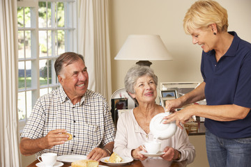 Senior Couple Enjoying Afternoon Tea Together At Home With Home Help