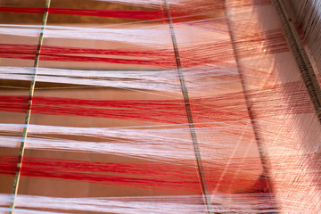 Weaving equipment with woven yarn in the background