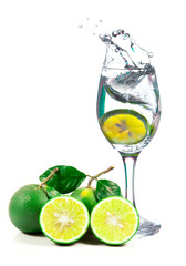 Fototapeta na wymiar Lime splashing into glass of water on white background