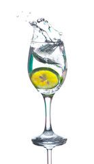 Lime splashing into glass of water on white background