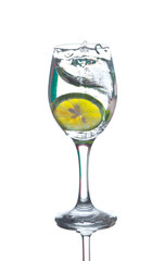 Lime splashing into glass of water on white background