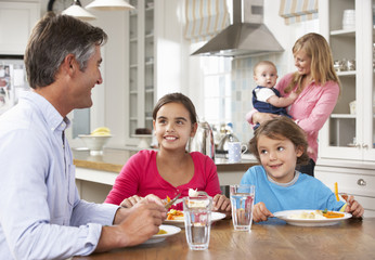 Family Having Meal In Kitchen Together