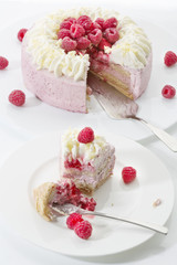 Himbeer-Sahnetorte auf Tortenplatte, Stück Torte auf Teller