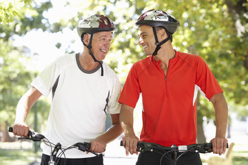 Two Men Cycling Through Park