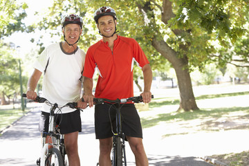 Two Men Cycling Through Park