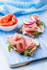 Open sandwiches with ham, tomato and arugula