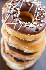 Pile of Glazed Doughnuts with colourful sprinkles, chocolate, ic