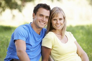 Obraz premium Couple Relaxing In Sunny Summer Field