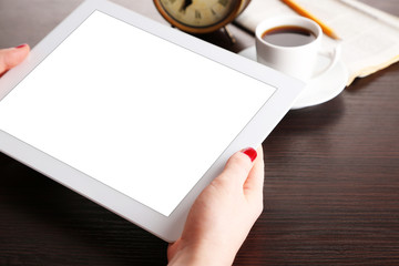 Obraz premium Tablet ina female hands on table background