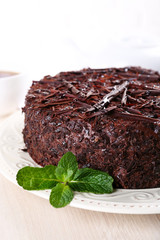 Chocolate cake with mint on table, close-up