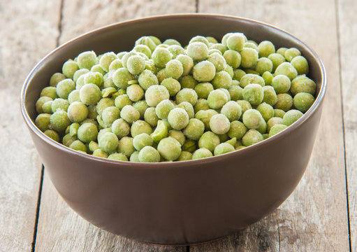 Fresh frozen peas in bowl close up