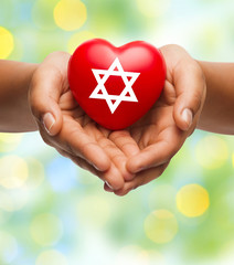 close up of hands holding heart with jewish star