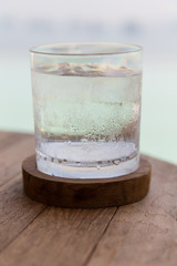 glass of water with ice cubes on table at beach