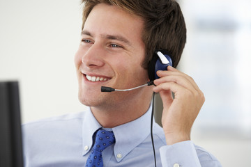 Friendly Service Agent Talking To Customer In Call Centre