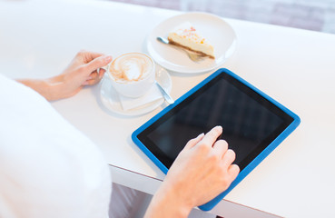 close up of woman with tablet pc drinking coffee
