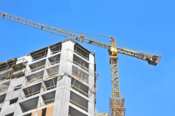 Crane and building construction site against blue sky