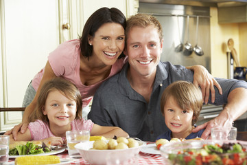 Family Eating Meal Together In Kitchen