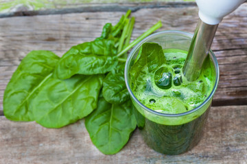 Preparing spinach smoothie for a meal