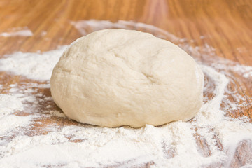 The dough and flour are on the table