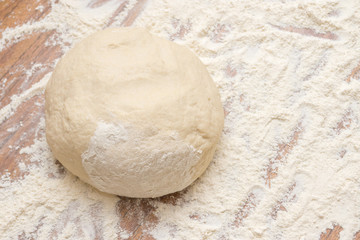 The dough and flour are on the table