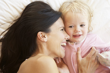 Mother And Daughter Relaxing In Bed