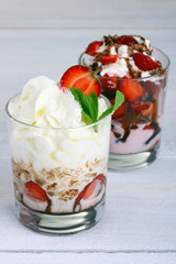Healthy layered  desserts with fresh strawberries and cream on wooden 