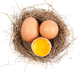 Chicken eggs in the nest of straw.