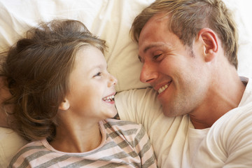 Father And Daughter Relaxing In Bed