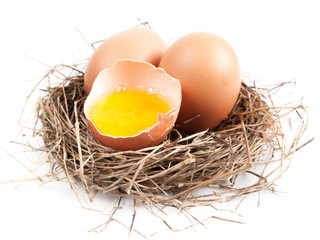 Chicken eggs in the nest of straw.