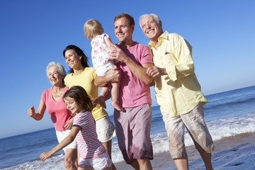 Fototapeta premium Multi Generation Family Running Along Beach Together
