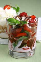 Healthy layered  desserts with fresh strawberries and cream on wooden 