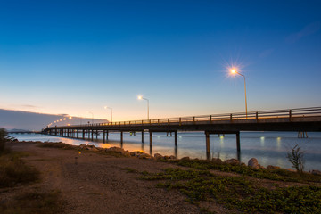 Fototapeta premium Concrete Bridge over sea water with sunrise