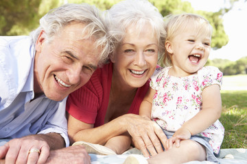 Grandparents And Granddaughter In Park Together