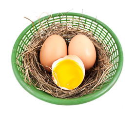 Chicken eggs in the nest of straw.