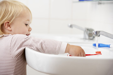 Obraz na płótnie Canvas Girl In Bathroom Brushing Teeth