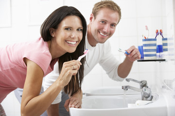 Couple In Bathroom Brushing Teeth