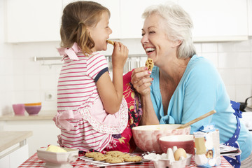 Grandmother And Granddaughter Baking In Kitchen
