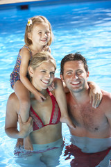 Obraz premium Family On Holiday In Swimming Pool