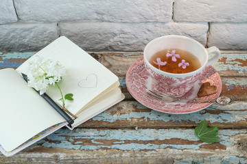 Cup of fresh herbal tea on wooden table.