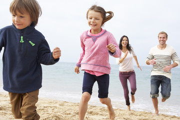 Obraz premium Family Playing On Beach Together