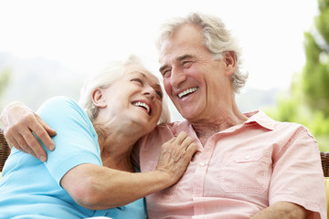 Senior Couple Sitting On Outdoor Seat Together